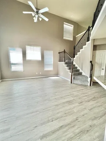 a view of a livingroom with wooden floor and a ceiling fan