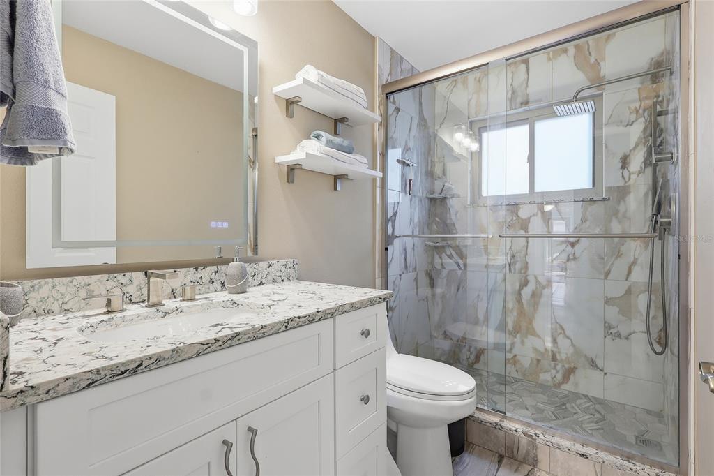 3488 Ridge Boulevard Palm Harbor, FL 34684 - Photo 22 of 30 a bathroom with a granite countertop sink toilet and shower
