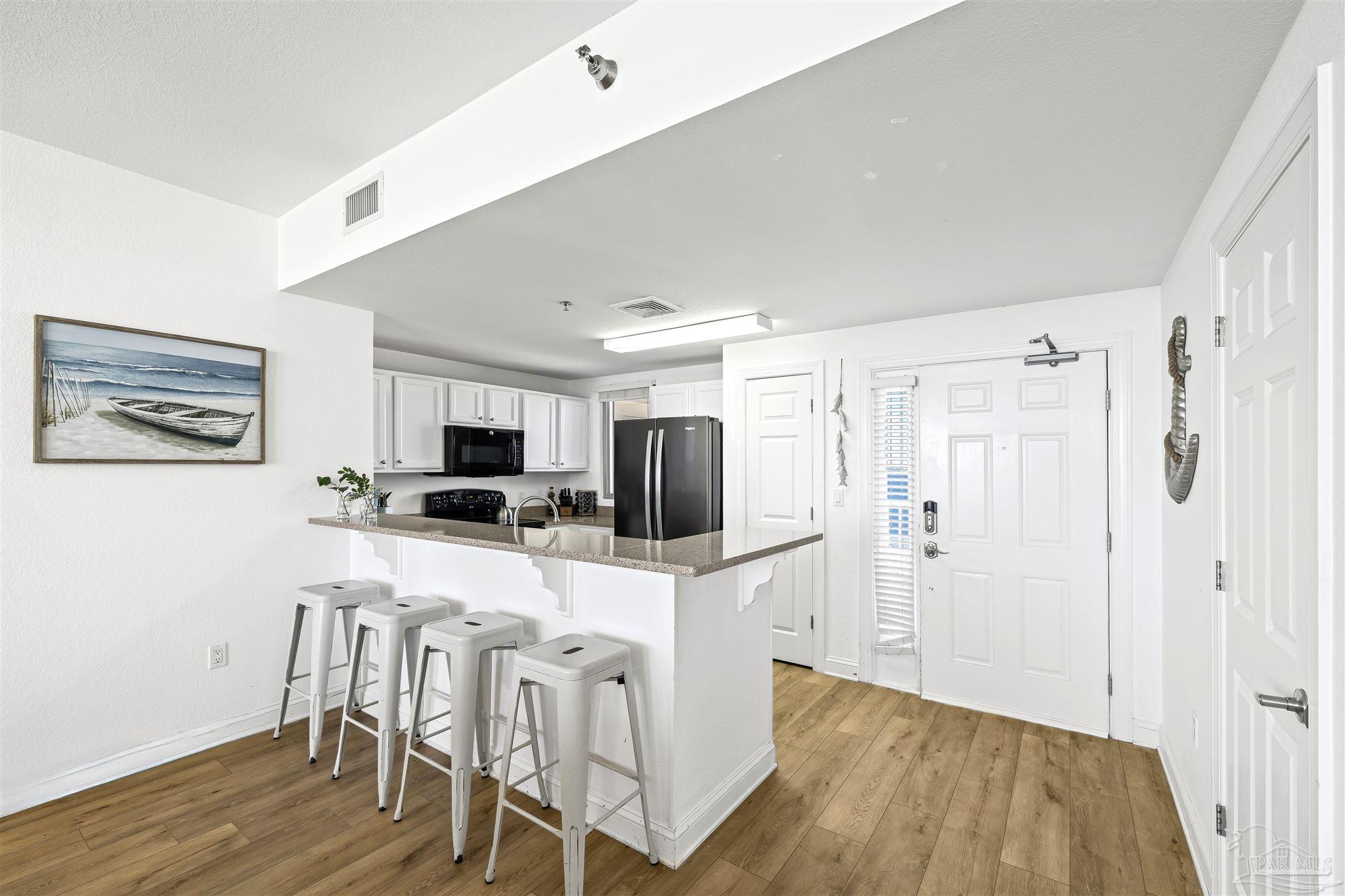 850 Fort Pickens Road, Unit 1040 Pensacola Beach, FL 32561 - Photo 11 of 37 a kitchen with stainless steel appliances a refrigerator and a stove top oven