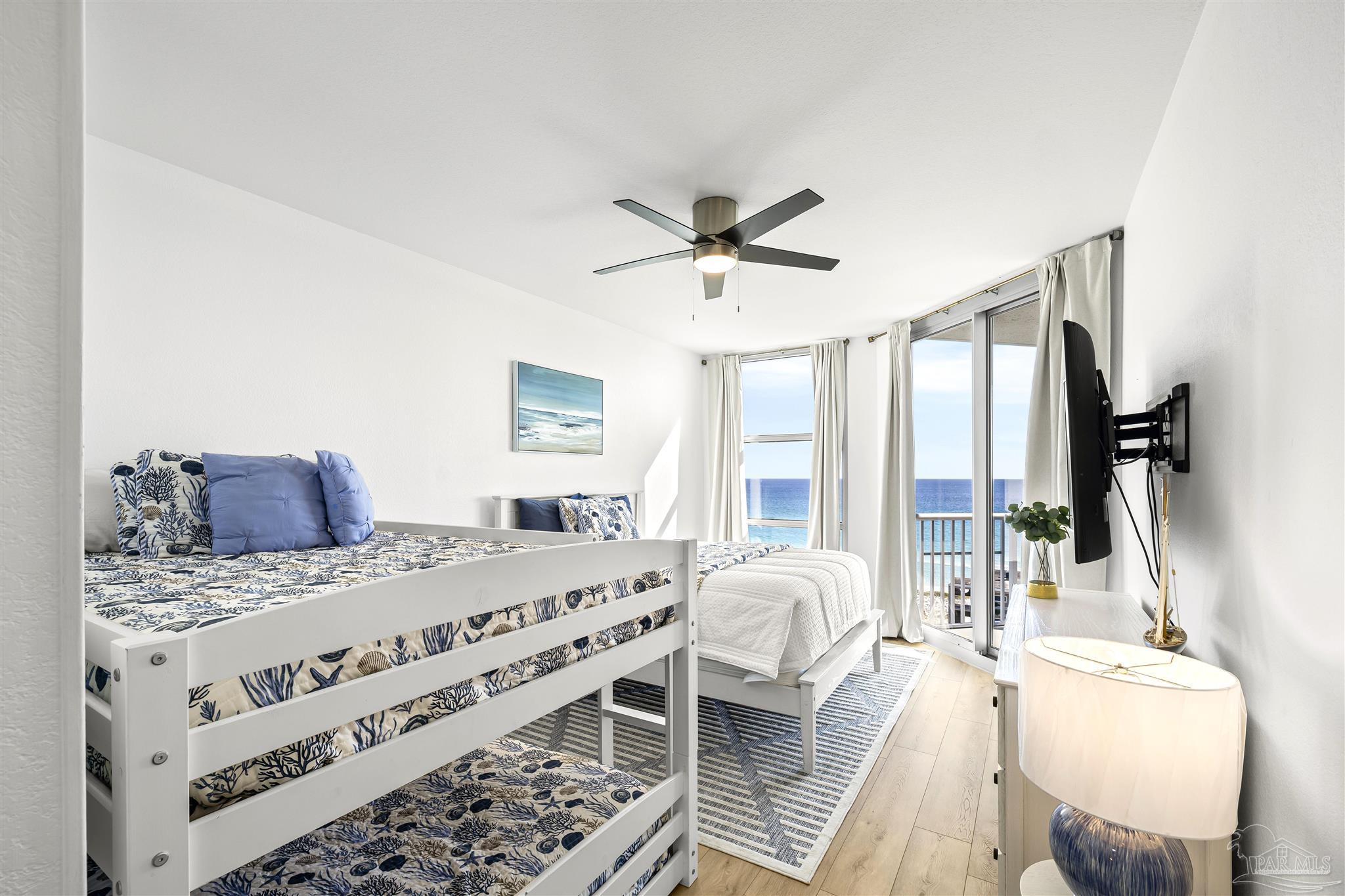 850 Fort Pickens Road, Unit 1040 Pensacola Beach, FL 32561 - Photo 16 of 37 a bed room with a bed a couch and a large window