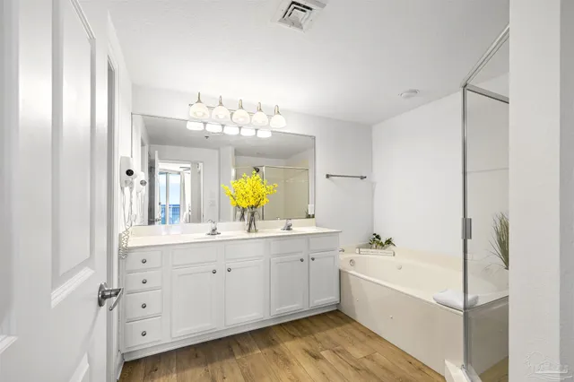 a bathroom with a tub a sink and mirrors