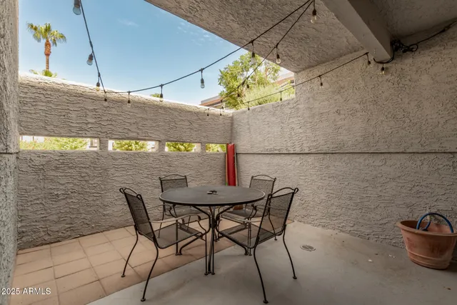 a view of a patio with table and chairs and potted plants