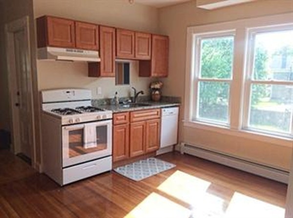 12 Union Street Beverly, MA 01915 - Photo 2 of 19 a kitchen with stainless steel appliances granite countertop a stove a sink and a refrigerator