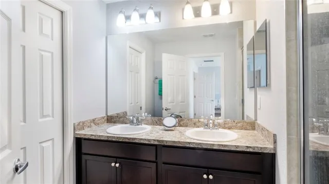 a bathroom with a granite countertop sink and a mirror