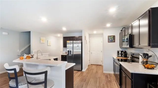 a kitchen that has a table chairs in it and wooden floors