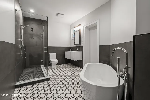 a bathroom with a sink a toilet a mirror and shower