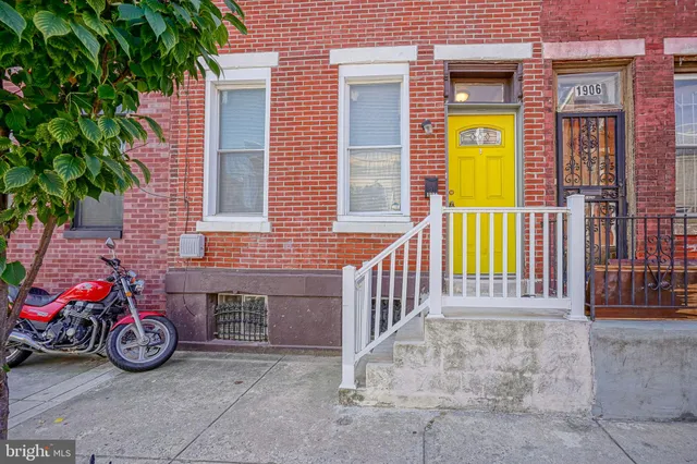 a view of a house with a porch and a car parked in front of it