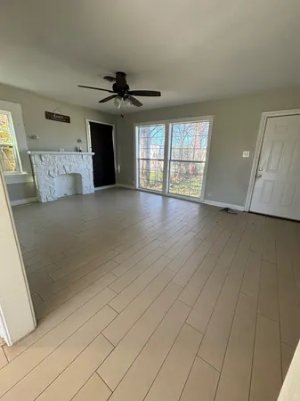 an empty room with windows and fireplace