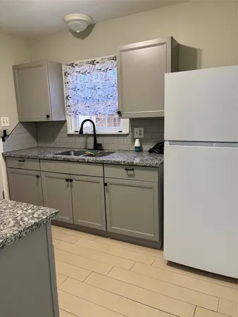 a kitchen with a sink a refrigerator and cabinets