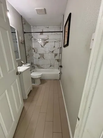 a bathroom with a sink a toilet a window and shower