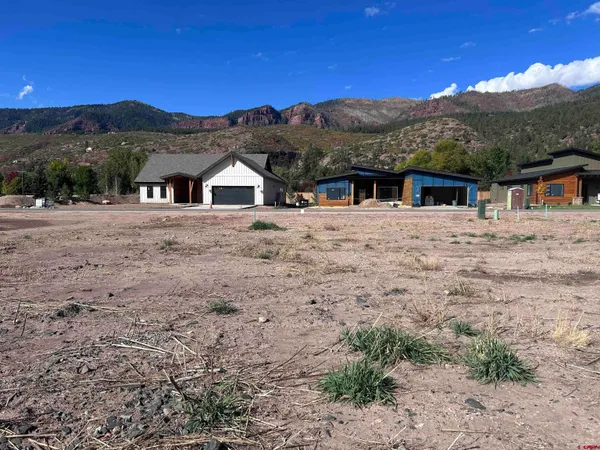 a view of a large house with a mountain yard and large trees