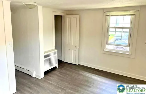 a view of a livingroom with wooden floor and window