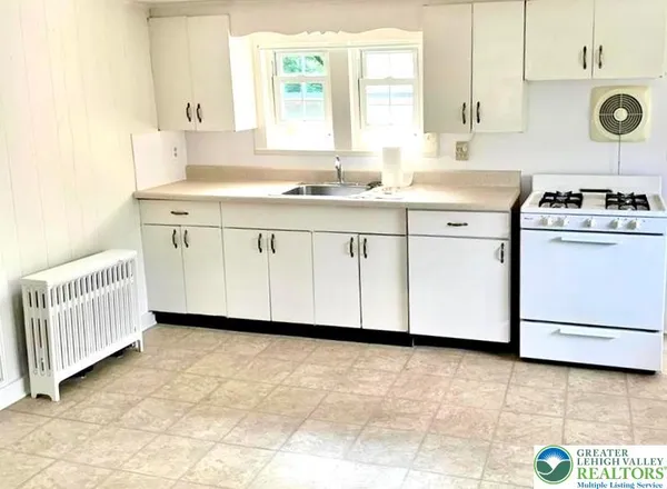 a kitchen with a sink cabinets and window