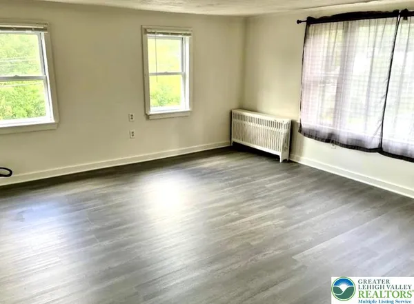 a view of a room with wooden floor and a window