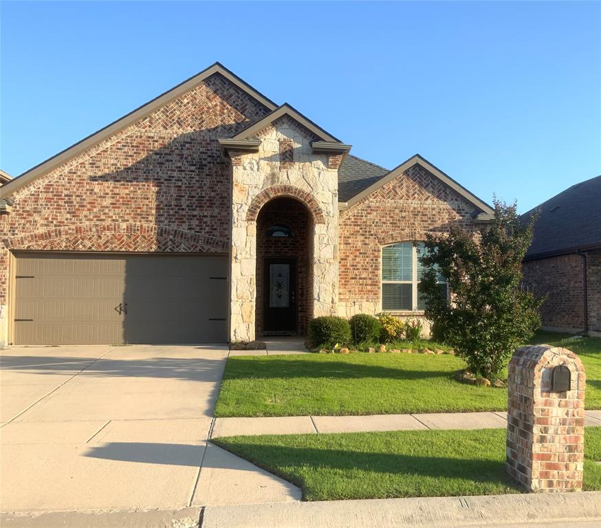 15805 Rockingham Street Frisco, TX 75036 - Photo 1 of 1 French country home with brick siding, stone siding, a front yard, and driveway
