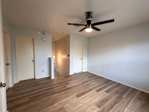 a view of empty room with wooden floor