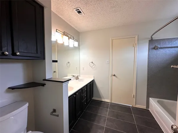 a bathroom with a granite countertop sink a mirror and a shower