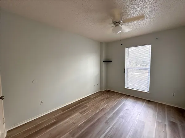 an empty room with a window and wooden floor