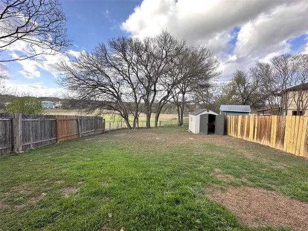 a view of a yard with a house and a large tree