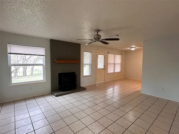 a view of an empty room with a fireplace and a window