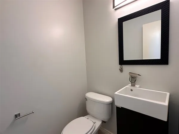 a bathroom with a toilet a sink and mirror