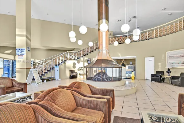 a living room with furniture kitchen view and a large window