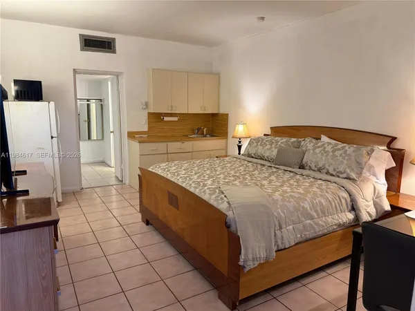 a bedroom with a bed and a flat screen tv
