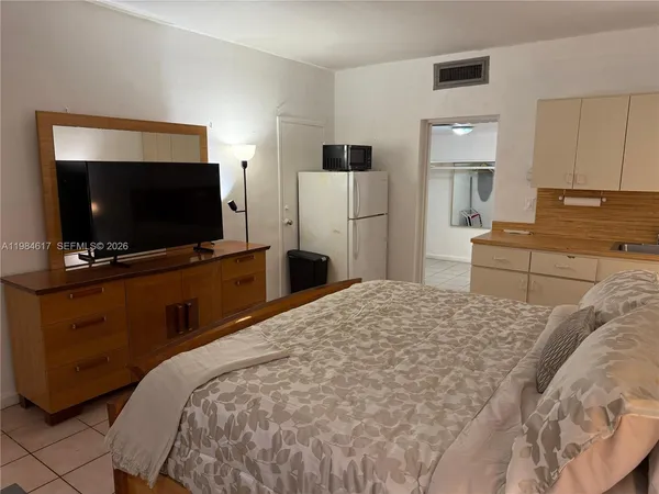 a bedroom with a bed and a flat screen tv