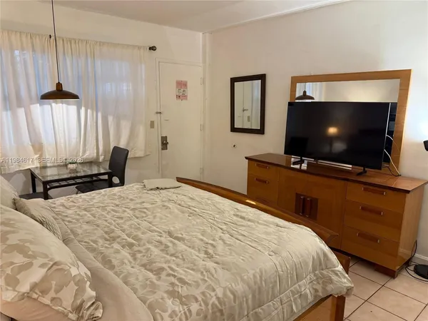 a bedroom with a bed and a flat screen tv