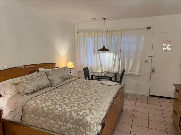 a large bed sitting in a kitchen next to a window