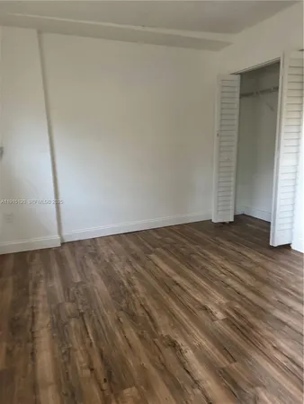 an empty room with wooden floor and door