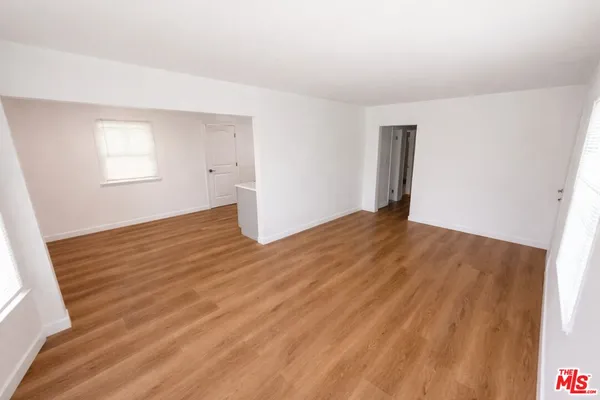 a view of a kitchen with wooden floor and electronic appliances