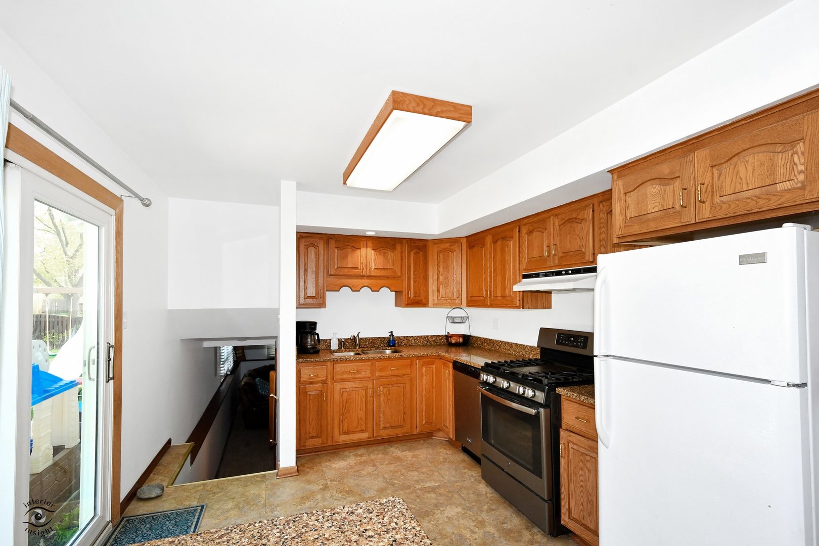 802 Timber Lane Darien, IL 60561 - Photo 8 of 23 a kitchen with a refrigerator a stove top oven a sink and a window