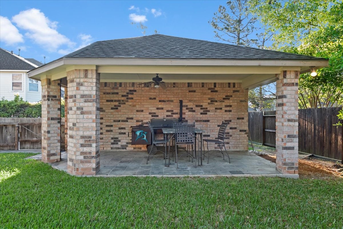 6507 Quiet Pointe Drive Spring, TX 77389 - Photo 6 of 45 Charming backyard cover patio with a brick structure and a gabled roof.