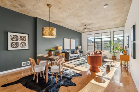 a living room with furniture a rug and a floor to ceiling window