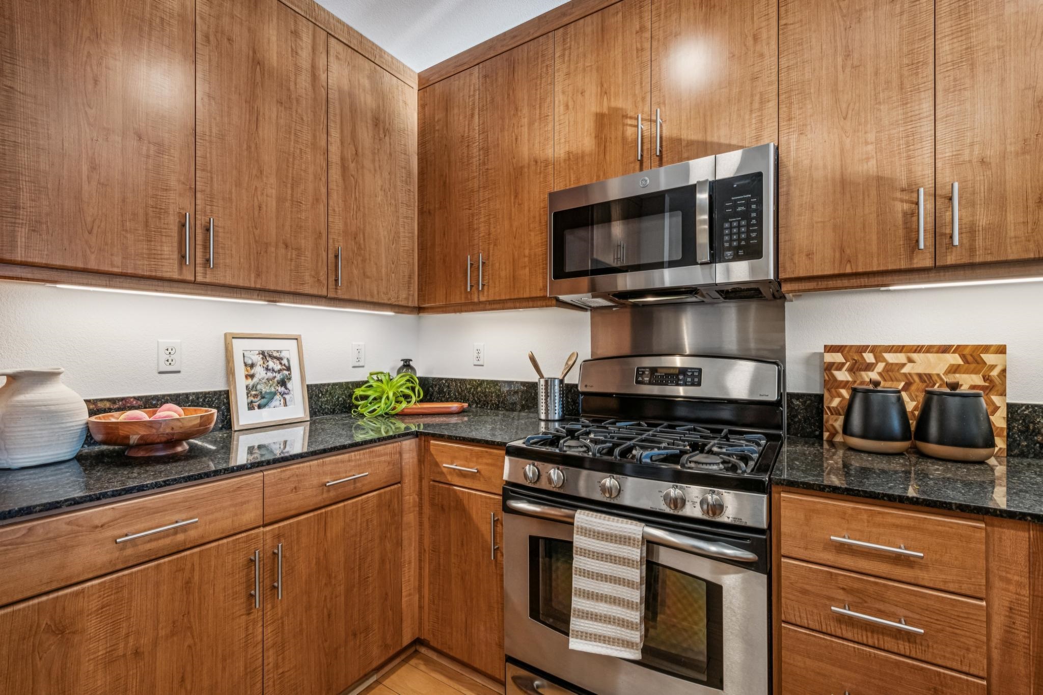 288 3rd Street, Unit 406 Oakland, CA 94607 - Photo 13 of 32 a kitchen with stainless steel appliances granite countertop a stove a sink and a microwave