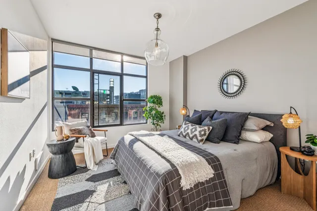 a bedroom with a large bed and a chandelier