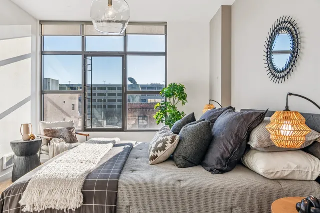 a spacious bedroom with a bed and a large window