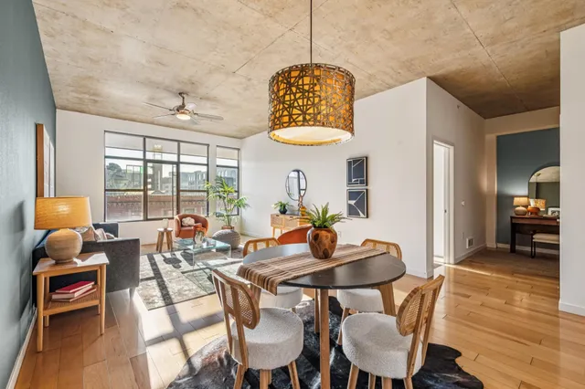a dining room with furniture a chandelier and wooden floor