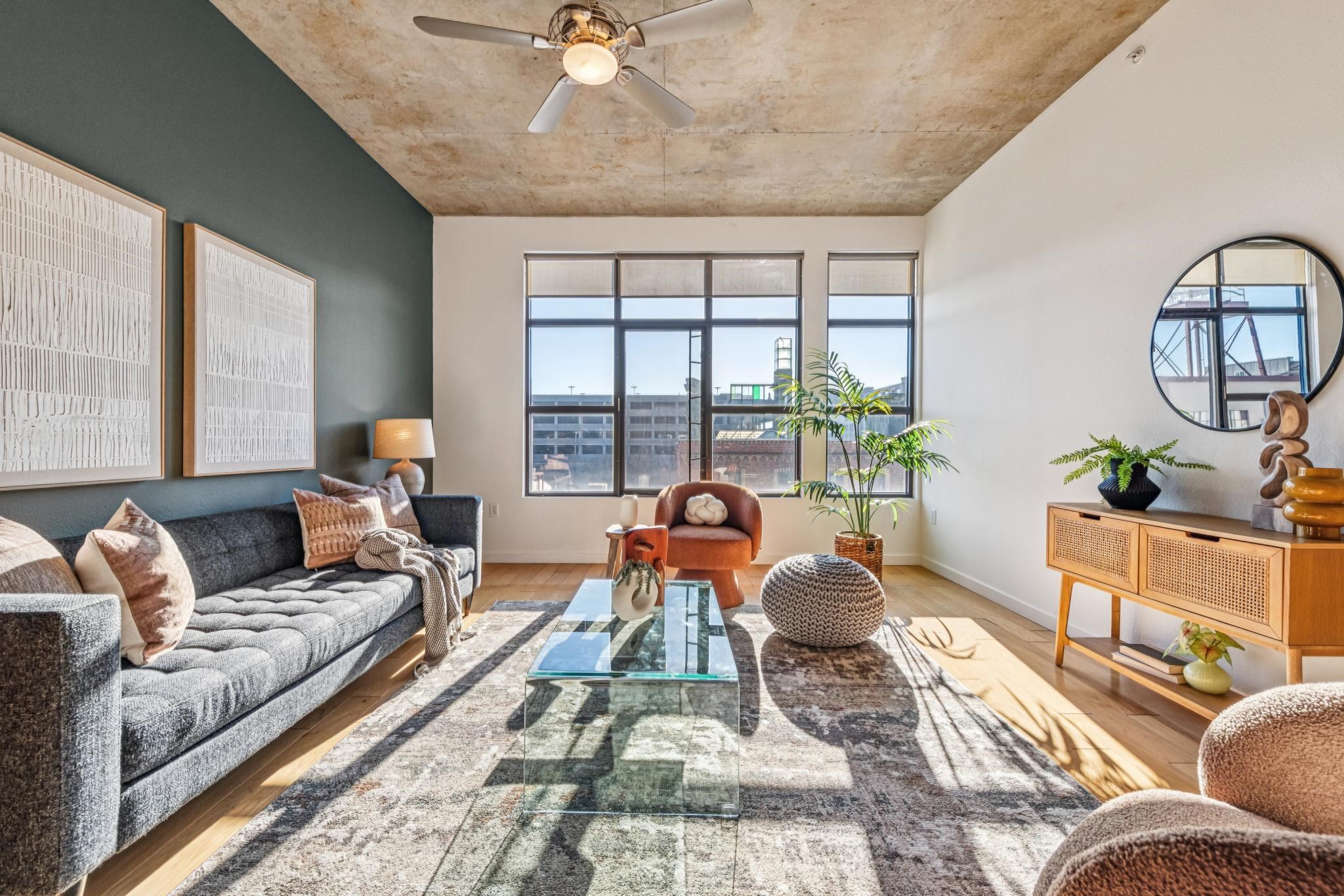 288 3rd Street, Unit 406 Oakland, CA 94607 - Photo 8 of 32 a living room with furniture a chandelier and a large window