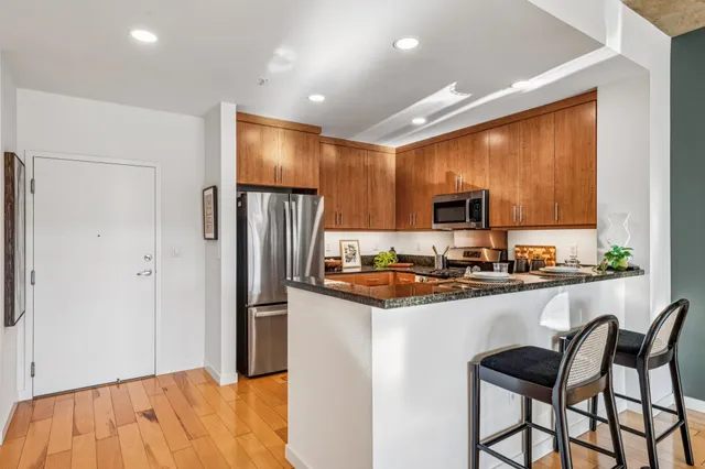 a kitchen with granite countertop a refrigerator stove microwave and sink