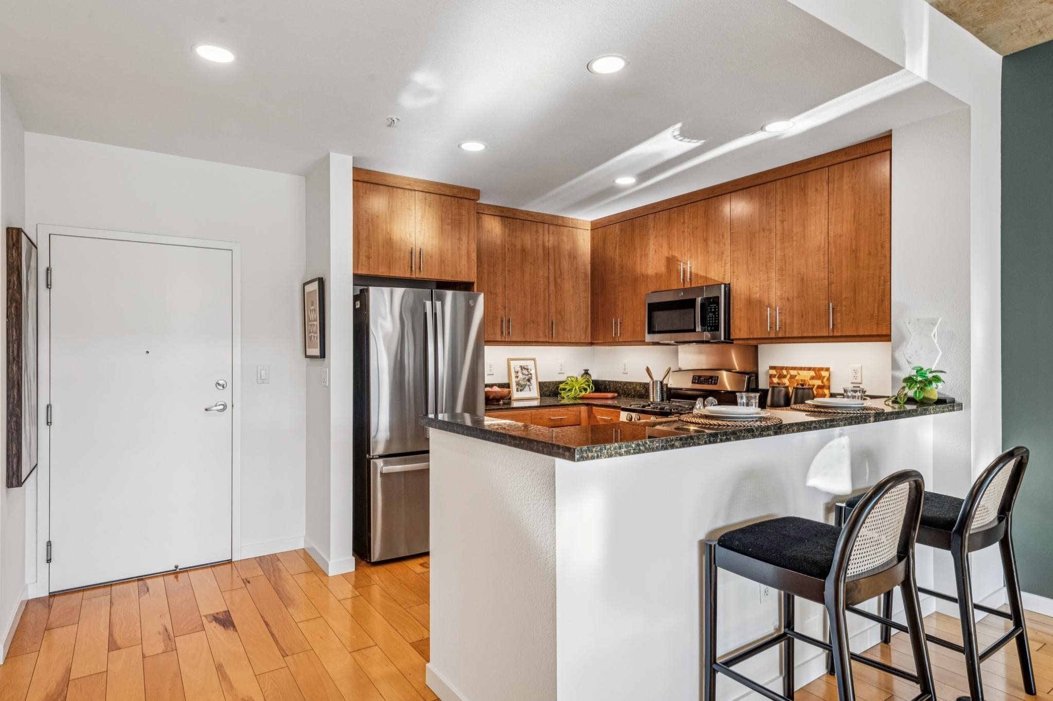 288 3rd Street, Unit 406 Oakland, CA 94607 - Photo 10 of 32 a kitchen with granite countertop a refrigerator stove microwave and sink