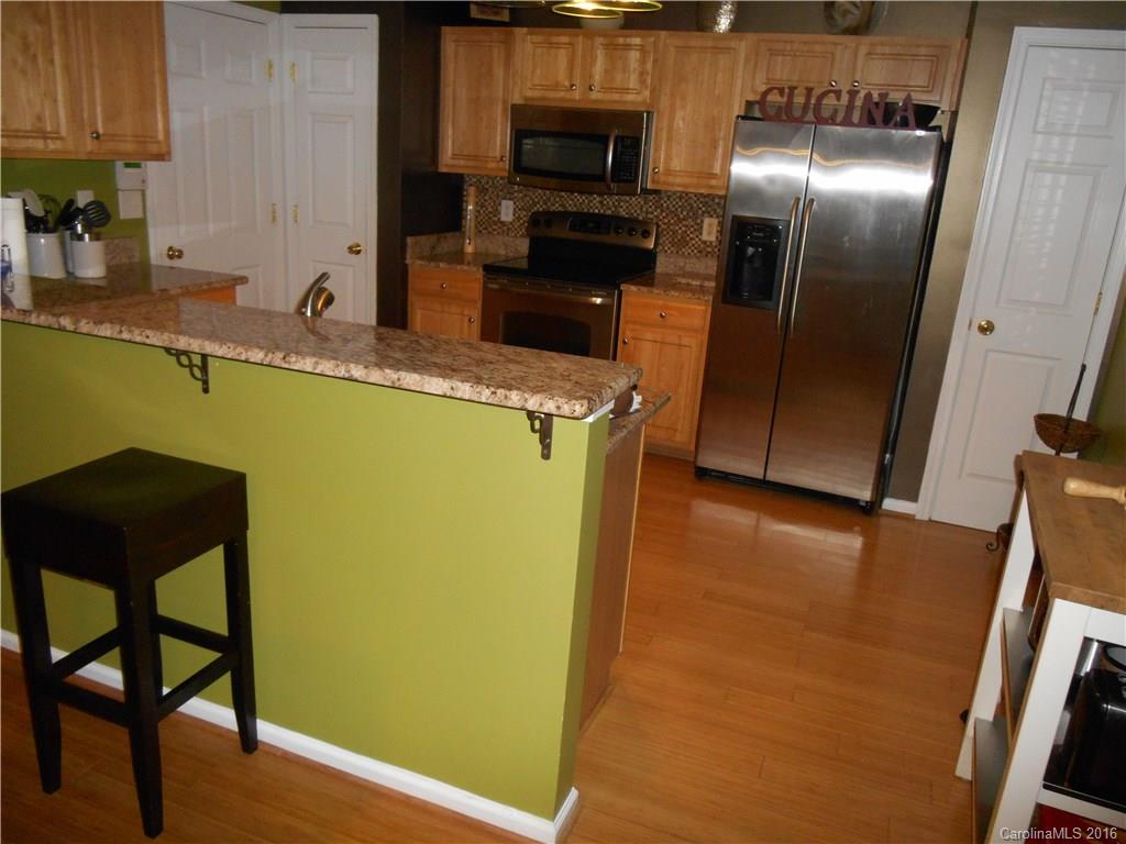 808 Valley Ridge Road Charlotte, NC 28214 - Photo 8 of 19 a kitchen with stainless steel appliances granite countertop a refrigerator a stove and a sink with wooden floor