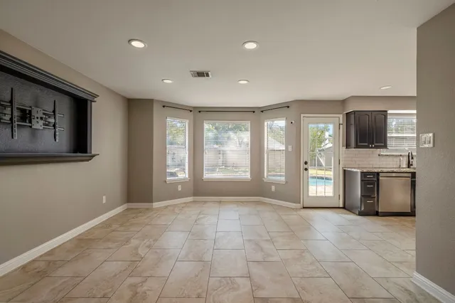a view of an empty room with a fireplace and a window