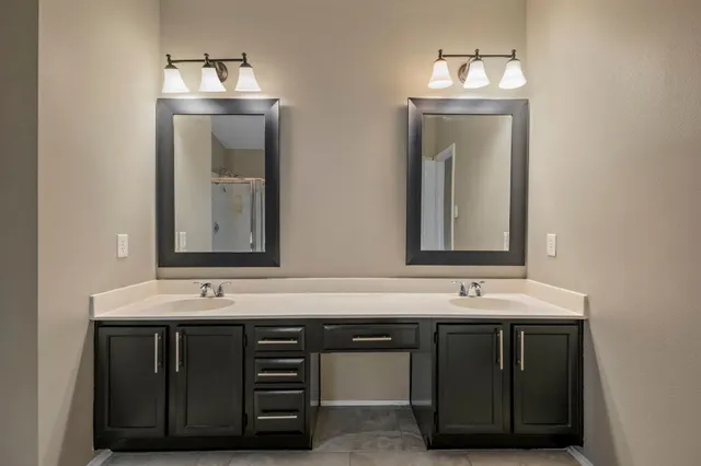a bathroom with a double vanity sink and a mirror