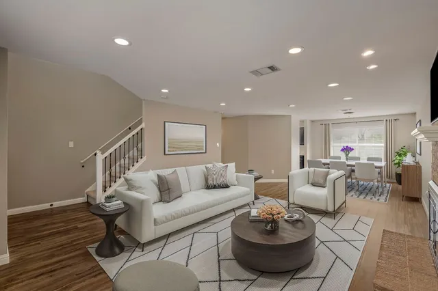 a living room with furniture and a wooden floor