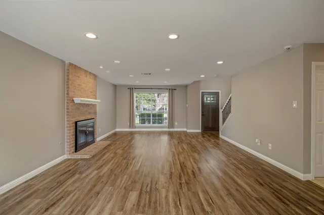 a view of an empty room with a window and fireplace