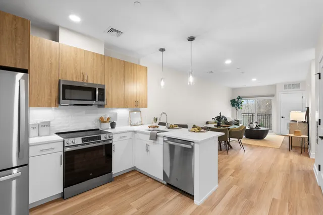 a open kitchen with stainless steel appliances granite countertop a stove and a wooden floors