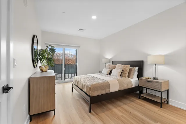 a bedroom with a bed and wooden floor