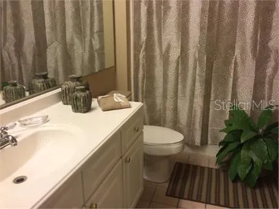 a bathroom with a sink a toilet and shower curtain